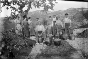 Grup de pagesos de Tivissa, format per homes i dones de diverses edats, mostrant els cabassos obtinguts durant la verema