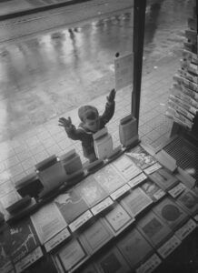 Un nen mira uns llibres des de l'altra banda del vidre d'una llibreria, a Barcelona