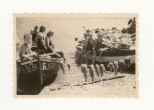 Excursió en barca a la cala Montjoi (Roses) d'un grup d'amics amb mainada i preparació d'enfilalls de peix per coure a la sorra de la mateixa platja