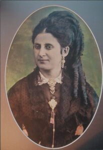 Bust femení acolorit dins d’un medalló, amb la cabellera de llargs tirabuixons, mig adreç d’or i corall i la cadena del ventall, d’un dels primers fotògrafs tarragonins, Pere Pallejà, amb estudi al carrer de Sant Fructuós i després al carrer de la Unió.
(AHT. Fons Joaquim Cabezas Rectoret. Reg. 288/35)