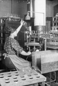 Une ouvrière fabrique une ampoule électrique dans une usine de la société [General Electric]