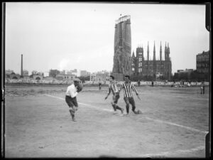 Match amical de football entre l'équipe nationale de Barcelone et l'Europe sur le terrain de l'Europa, avec le temple de la Sagrada Família en arrière-plan, 1917. Contexte et auteur : Frederic Juandó Alegret.